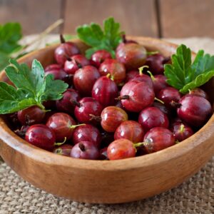 Red gooseberries in a wooden bowl