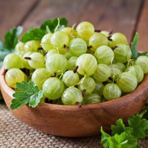 Green gooseberries in a wooden bowl