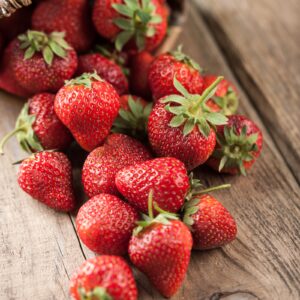 Red strawberry in the basket and on the table close-up